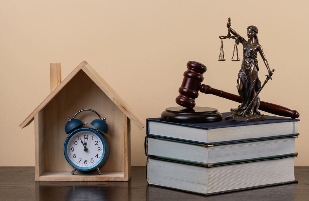 młot sędziowski, figura Themis, książki i symboliczny drewniany dom